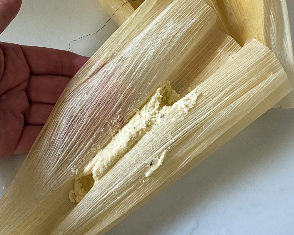  Use the husk to roll the masa edges together into a cylinder. 