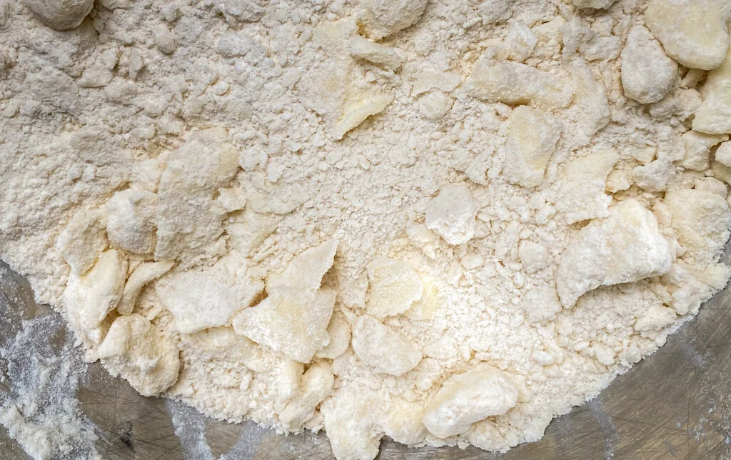 I mash the butter between my fingers, leaving it in largish flakes.