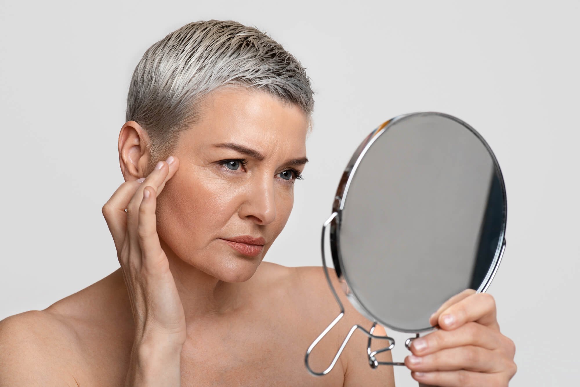 alt=woman looking in mirror