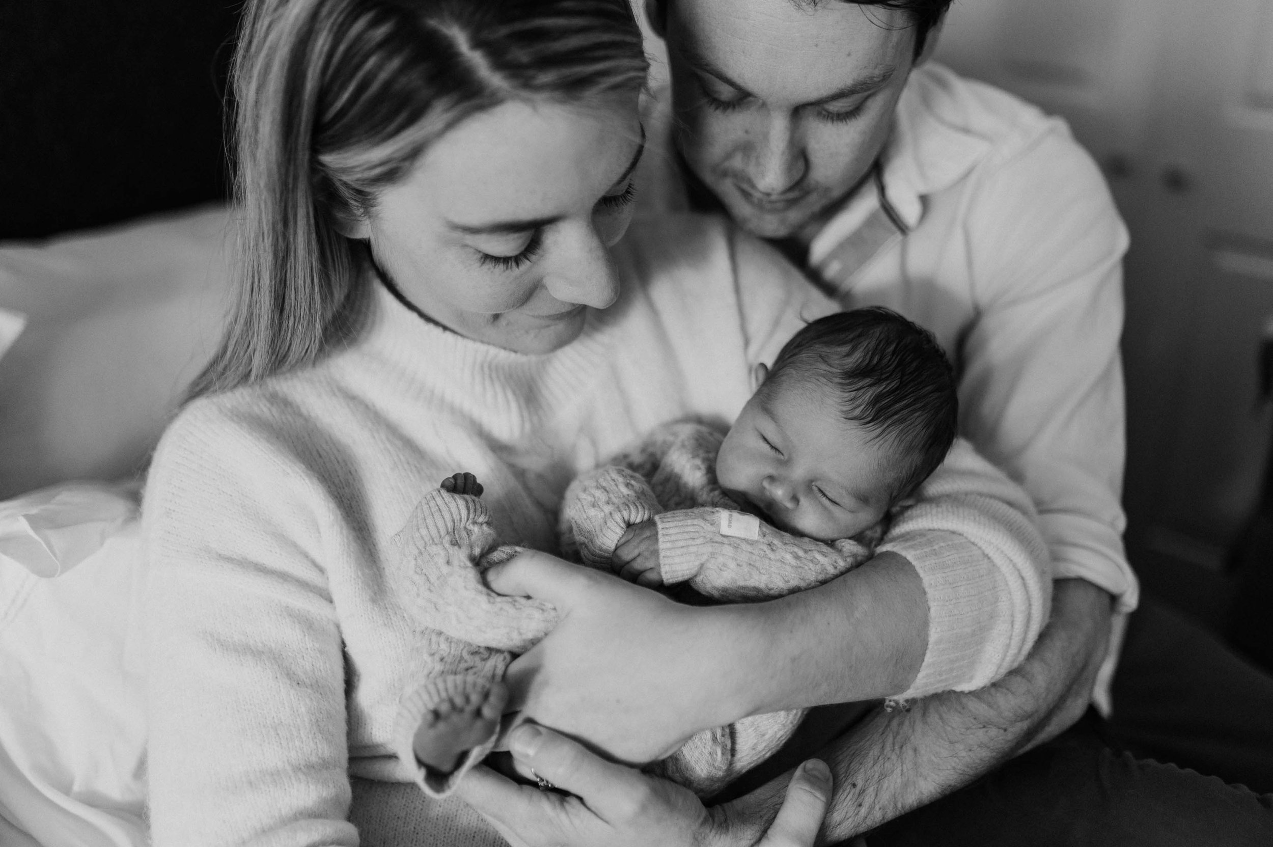 mum and dad holding sleeping baby