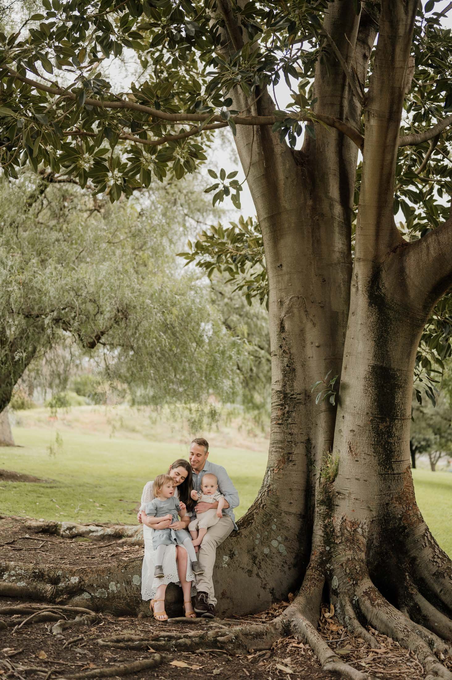 family hugging next to tree