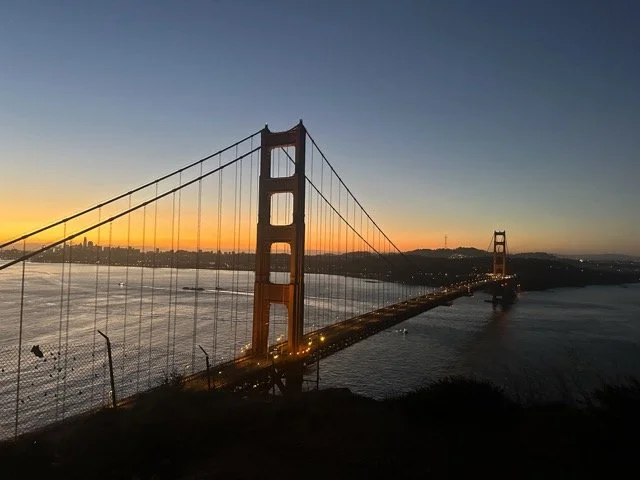 Golden Gate Bridge at sunset with city skyline in the background