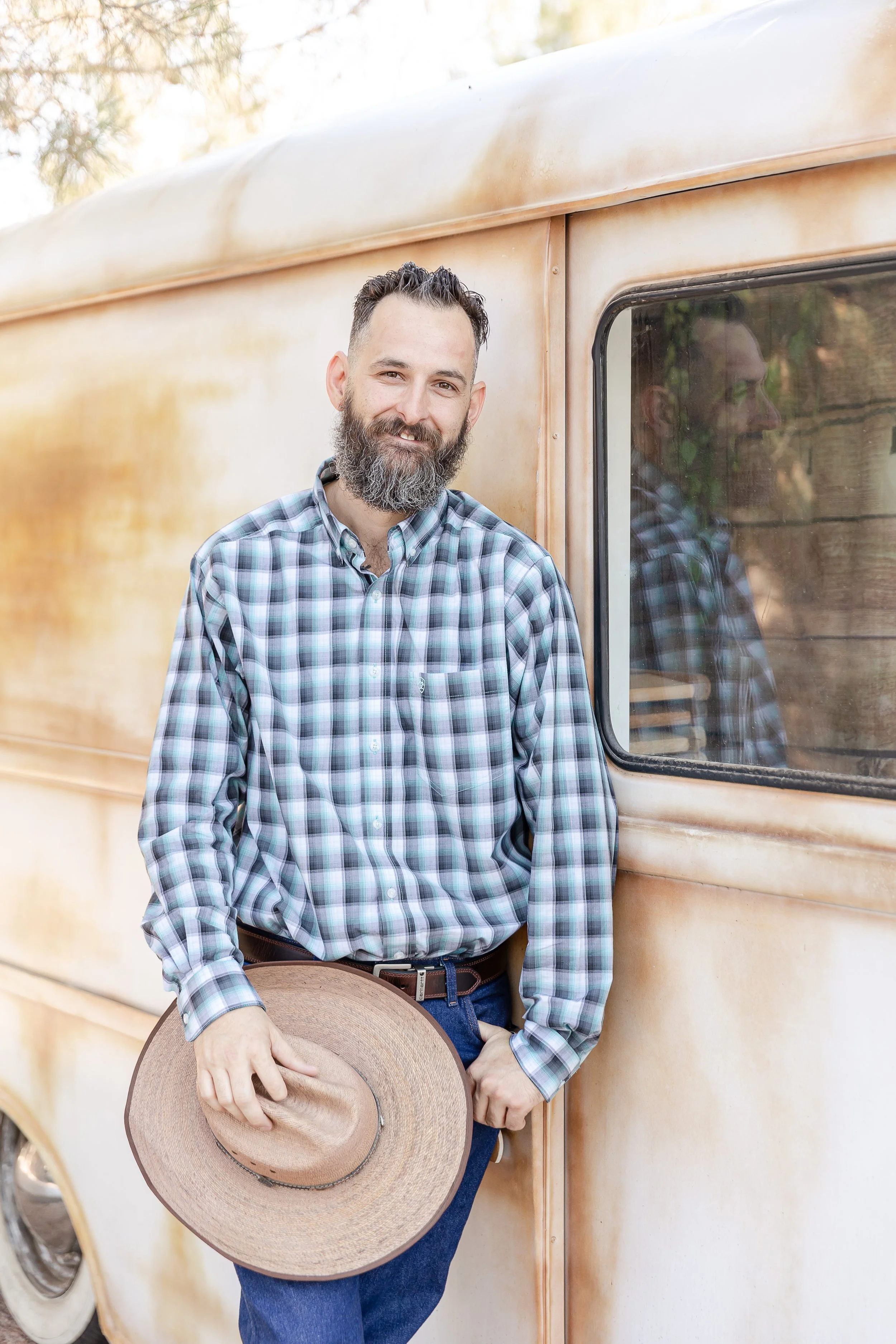 groom and his cowboy hat leaning on an old metro van