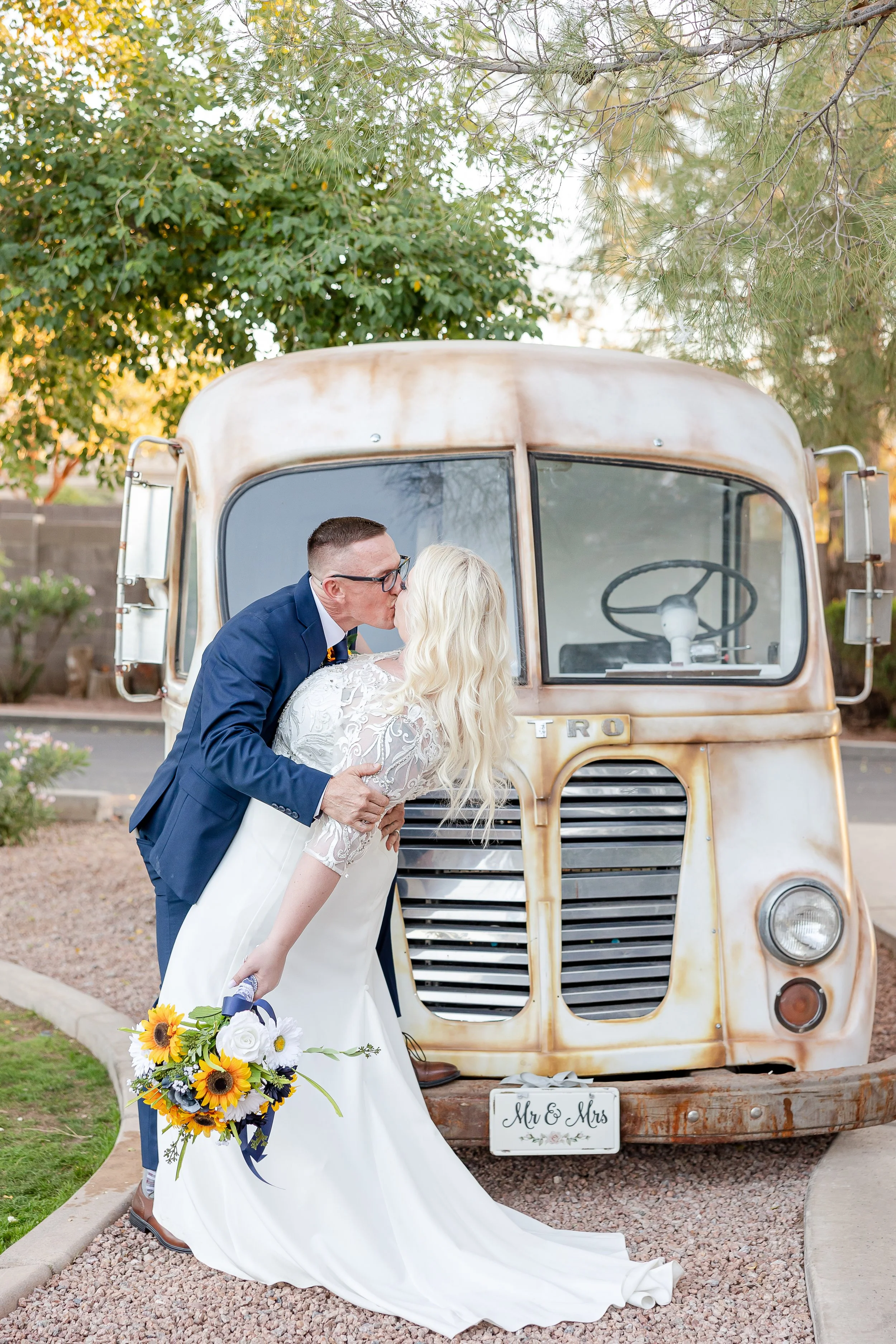 groom and bride kissing in front of metro van with meander gatherings