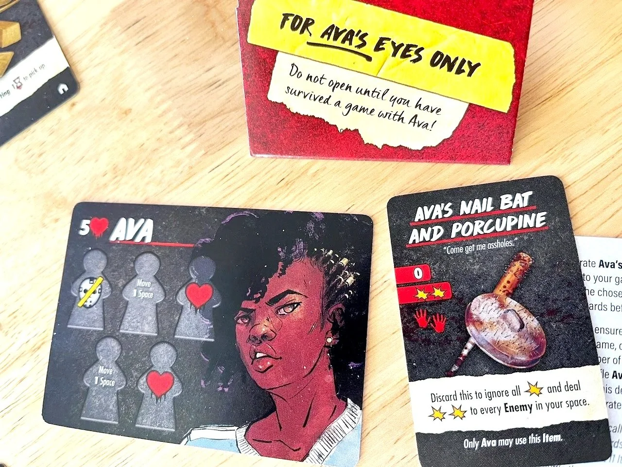 Picture of Ava character card from Final Girl: A Knock at the Door solo horror game, with envelope and special weapon that Ava unlocked.