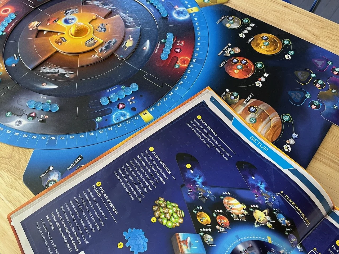 Detail of left hand page of SETI board game rulebook; board, token and planets in background.