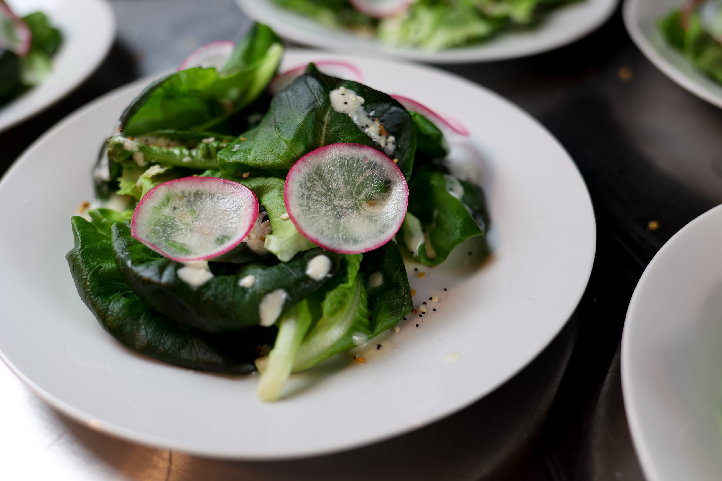 Little Gem Salad with lemon cream dressing, radish, + "everything" seasoning