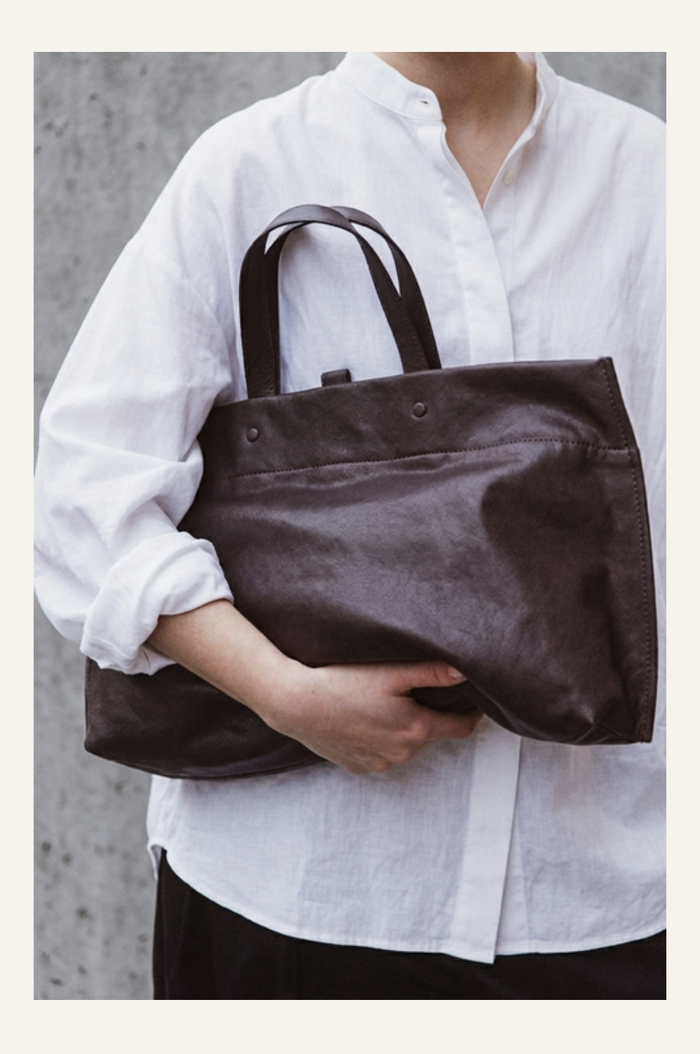 Lihann George Elli Bag in dark brown matte leather held by hand — Sabine Kohler Boutique.png