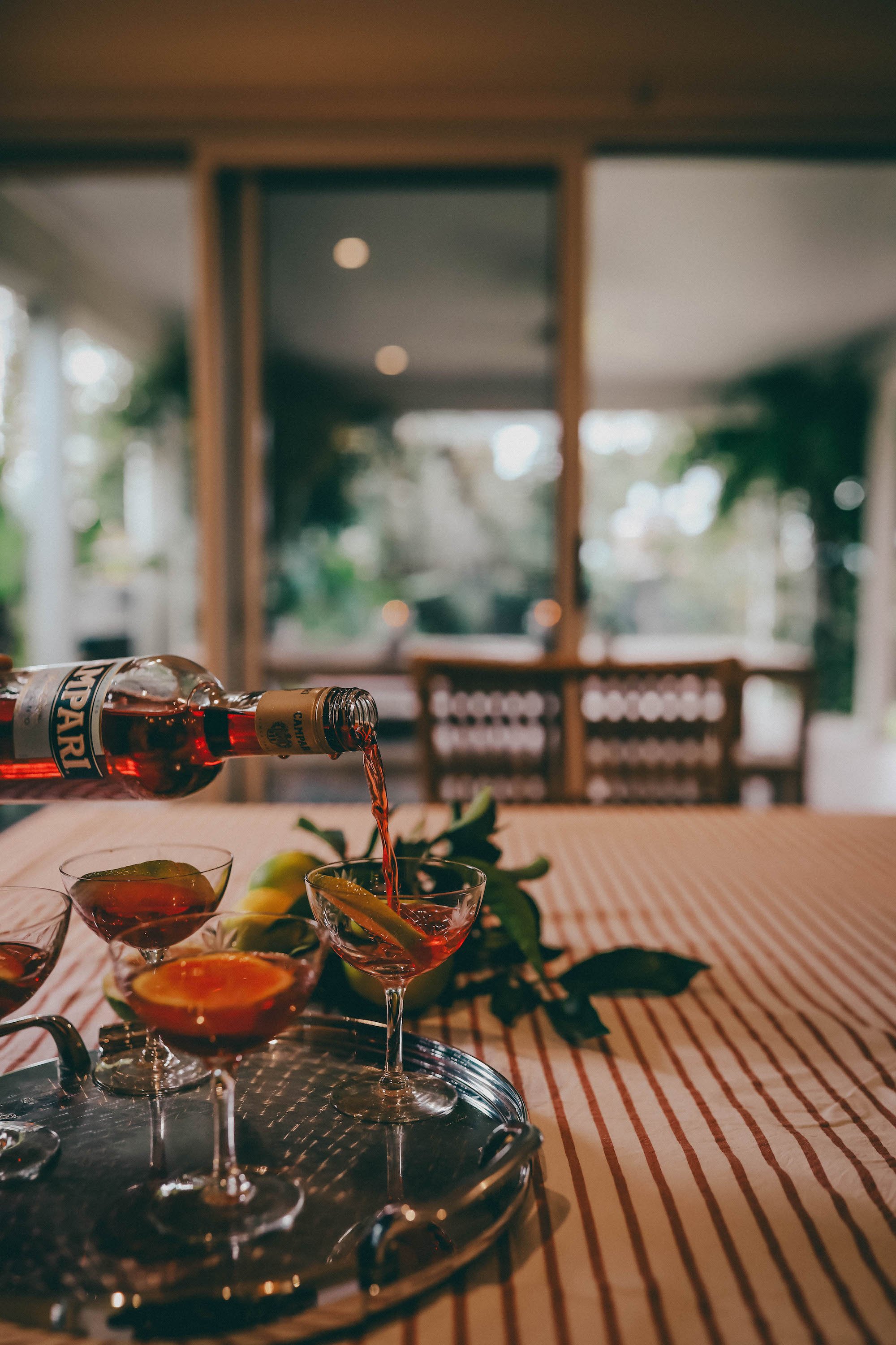 Negroni cocktail being poured with citrus, on the verandah at Verandah Retreat