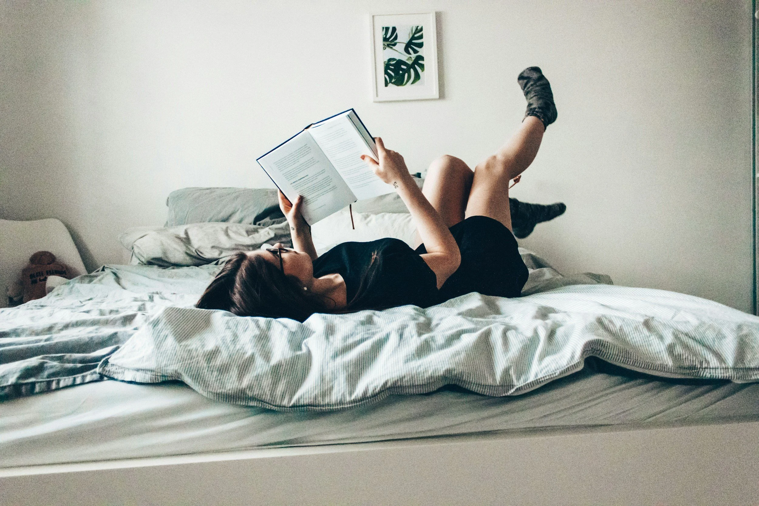 Woman reading in bed after a breakup