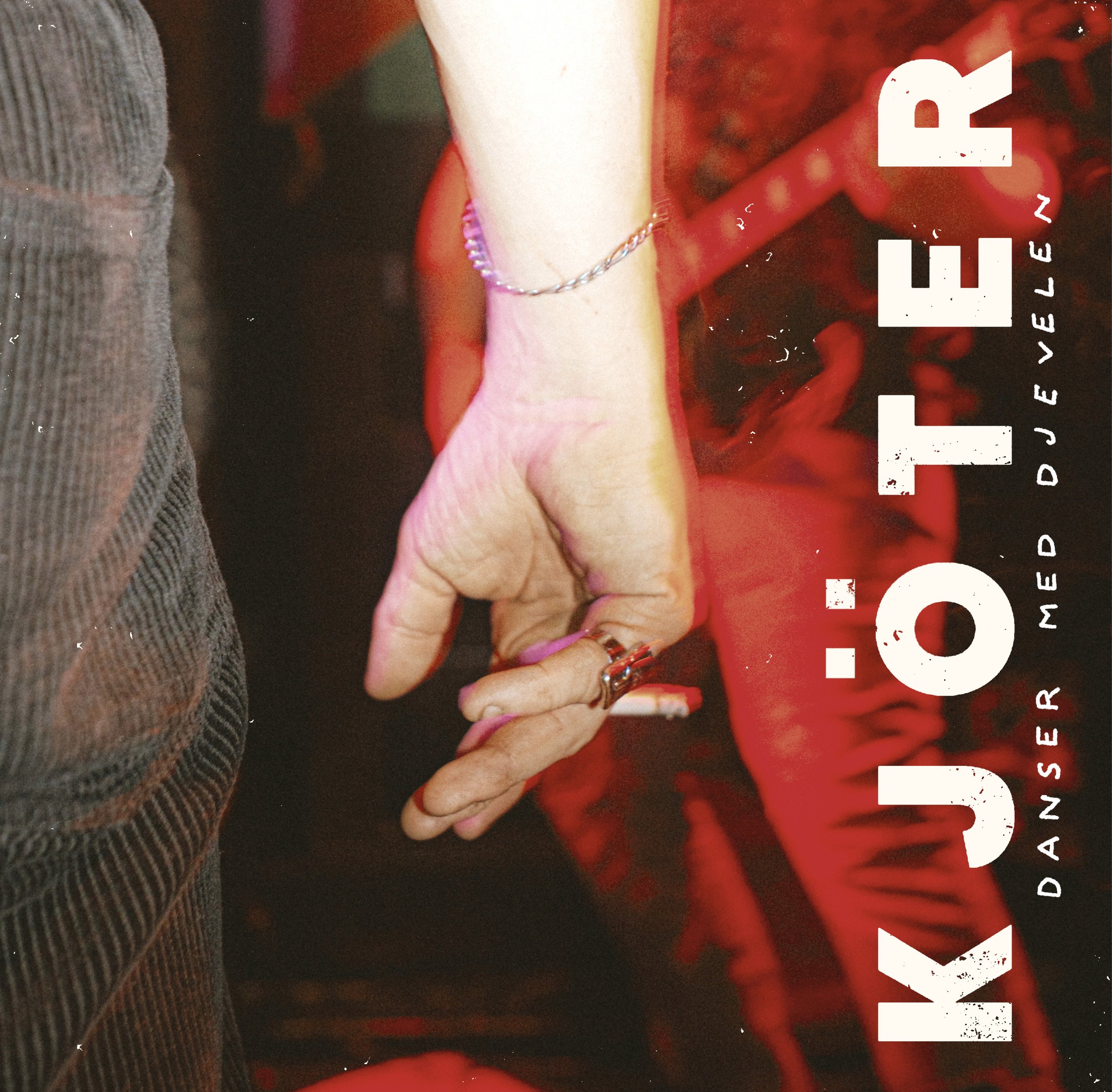 Close-up of a person holding a cigarette with red lighting in the background. The person is wearing rings and a silver bracelet.