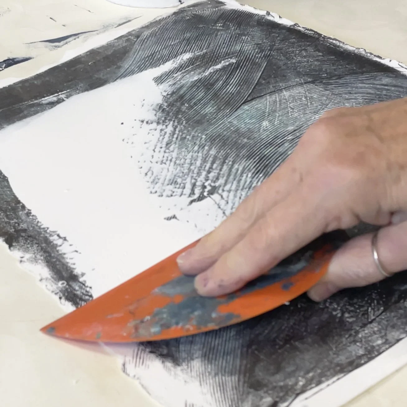 Messermeister silicone bowl scraper used by an artist for applying paint, scraping back layers and mixed media mark-making