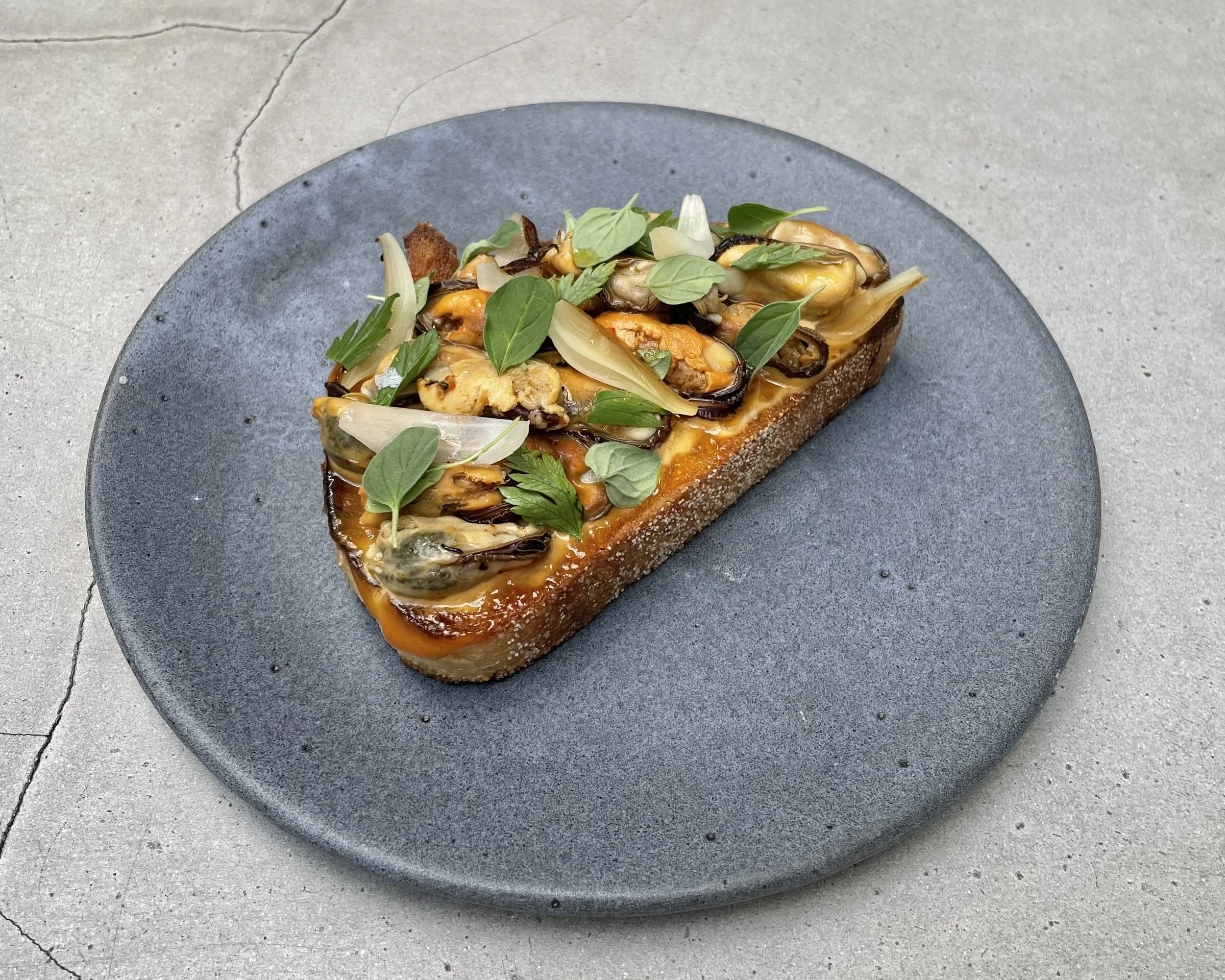 Mussels Escabeche on Toast with Gochujiang Aioli, Pickled Onion and Fresh Herbs
