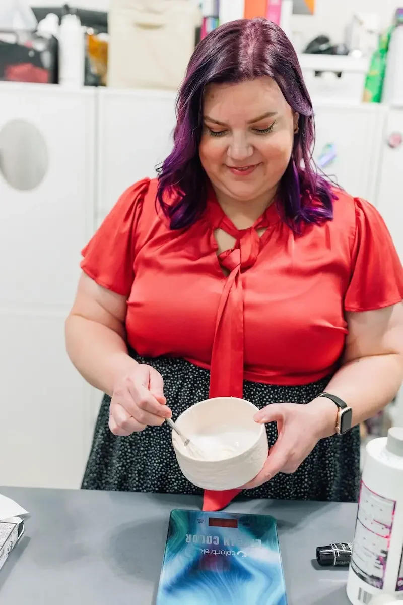 Stylist mixing hair color at The State Co salon in Livermore, CA, preparing professional hair products for a color service.