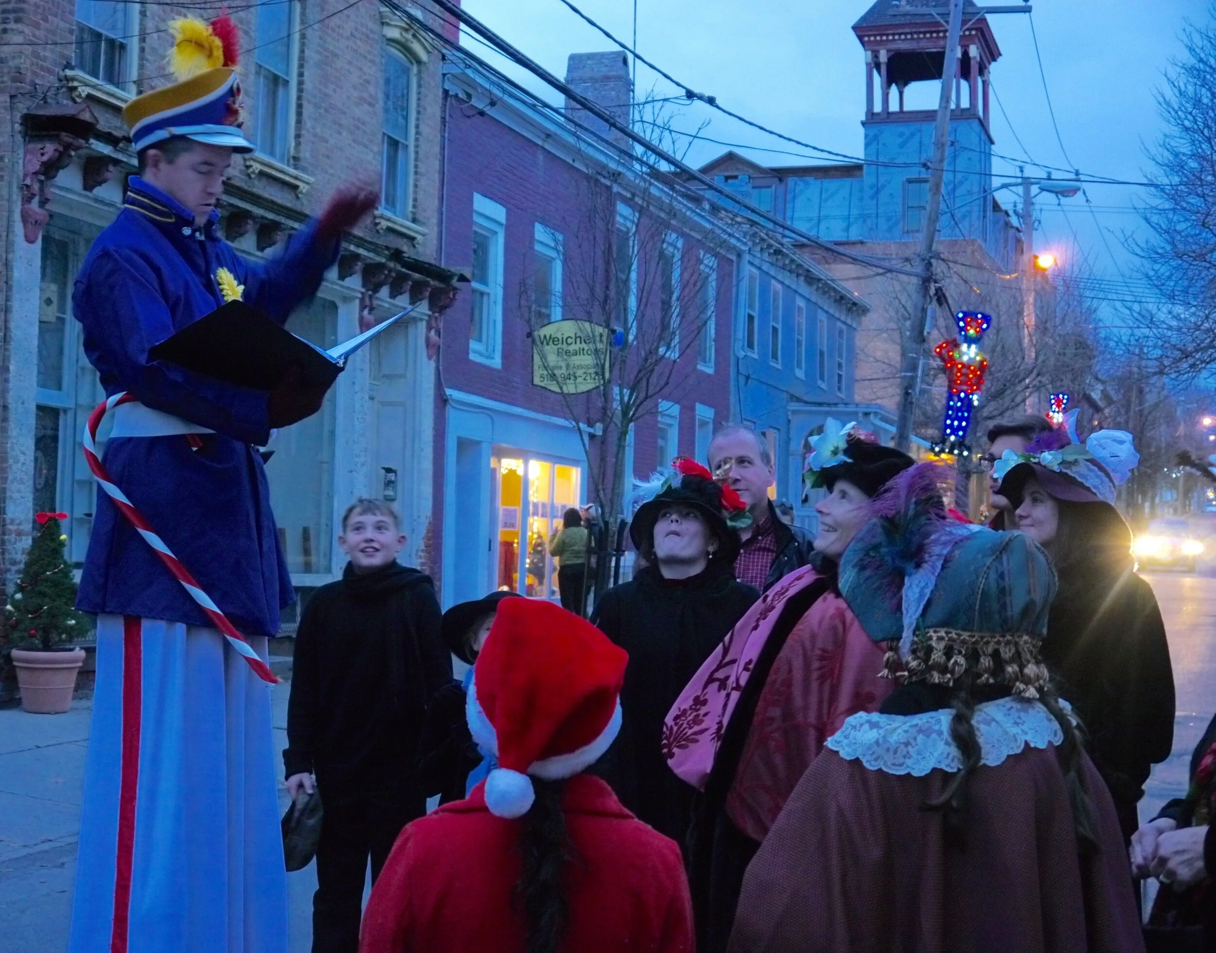 stroll-stilt-walker-leading-carolers.jpg