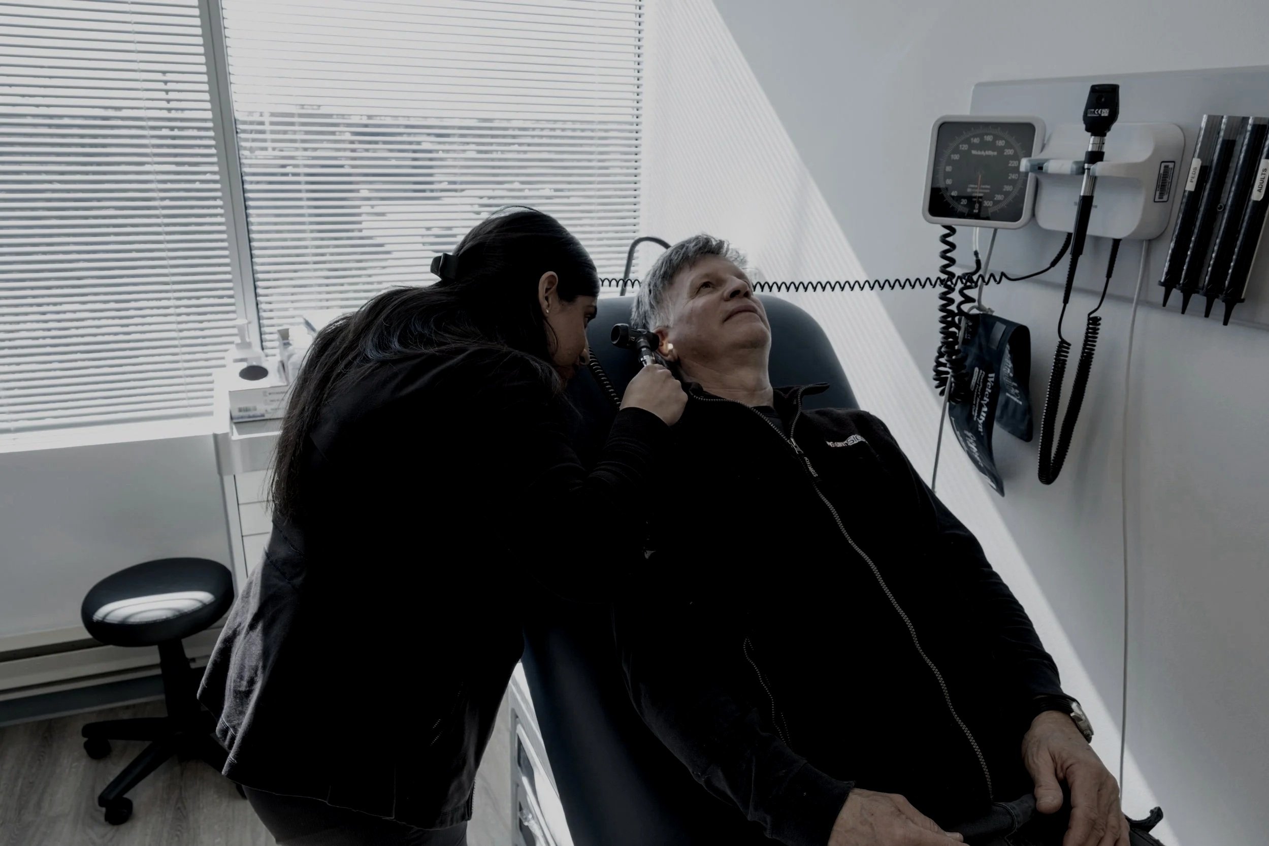 nurse examining patient on clinic bed