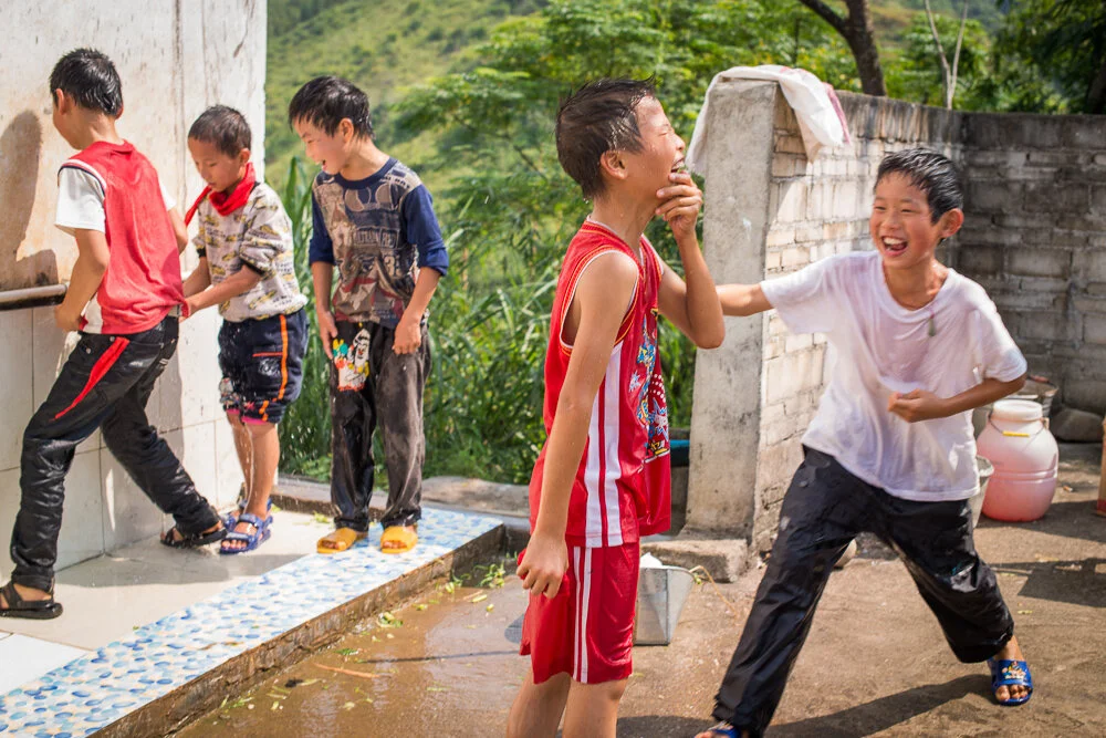 Students wash their faces after playing in a hot sunny day. 遊戲過後，學生在操場旁排隊洗臉消暑。