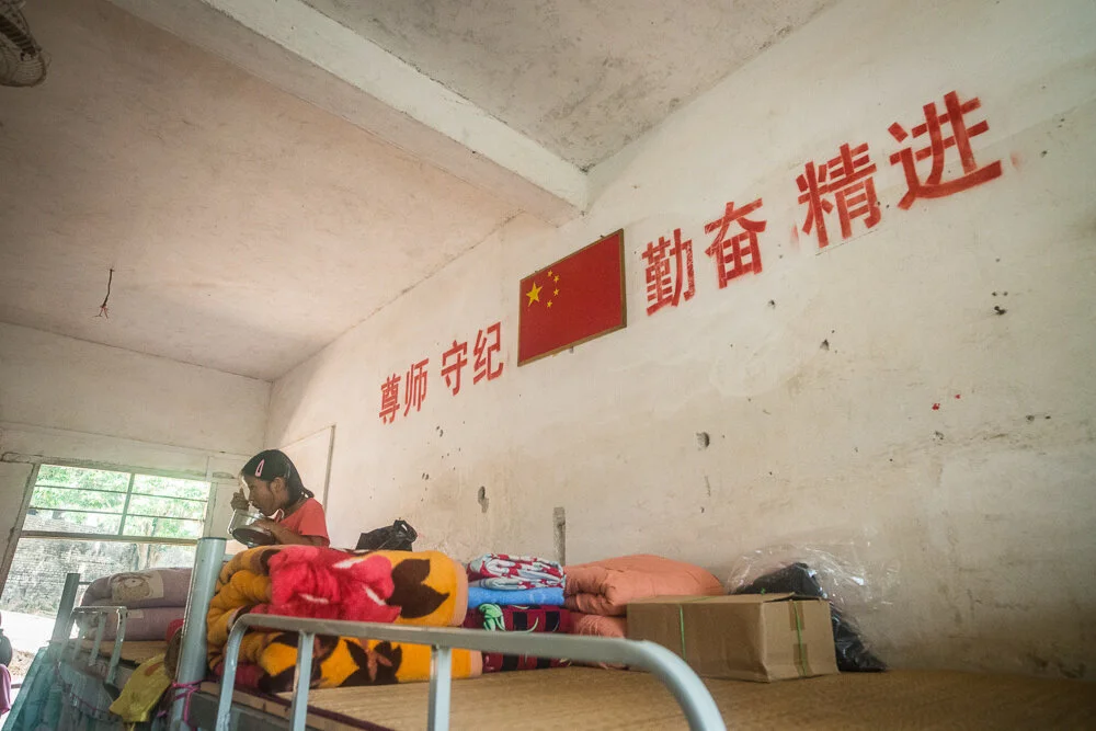 A girl eats lunch on her bed in the girl's dormitory, avoiding the heating sun outside. 在女生宿舍內，一名學生避開外間猛烈陽光，在架床上格吃飯。
