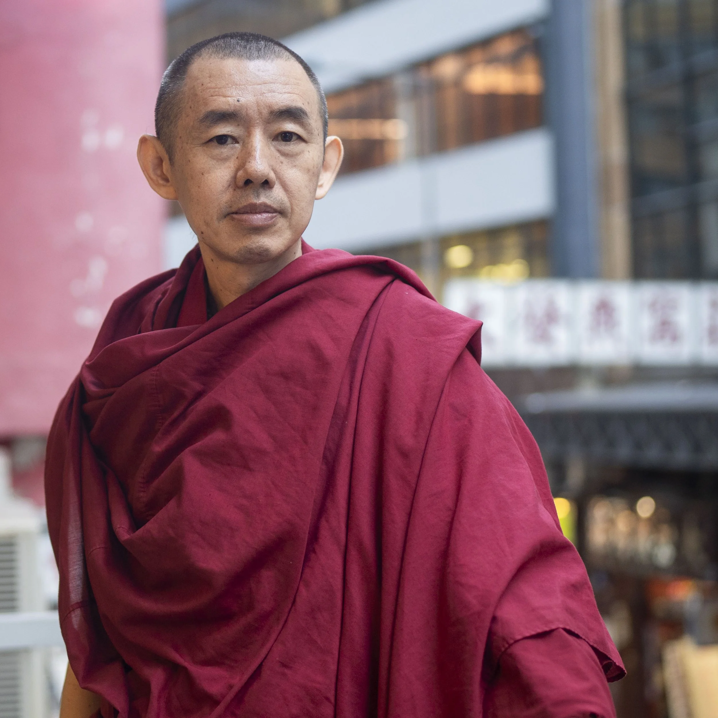 出家幾年後，喇嘛Sam 開始為法王拍照，希望把讓更多人看到他的肖像。法王攝影團隊，由本來只有他一人，現在已發展到有九人以上。
放下建立多年的身份認同並不容易，而且出家人拍照可以賺取生活費，「加上他是我師父，我希望跟他親近。」但他說，現在這種心態都放低了。
從前當記者可能沒想太多，Sam 現在認為，自己拍照符合佛教理念，「不會做傷害人或令人不快的事，例如故意偷拍。我為法王拍照時更恭敬一些，有時通過拍照，我可以進入一種清靜的境界。」
「全世界認識我的人，都知道我為法王拍照，以前覺得一生都要為他拍照，