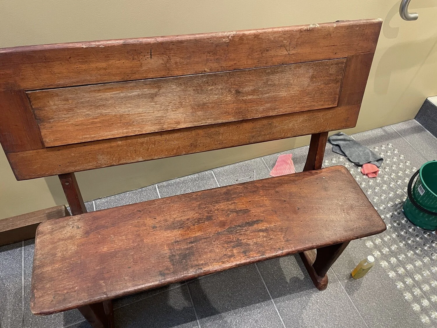 Cleaning and treatment of the benches in progress at the Heritage Centre with areas of carved graffiti visible