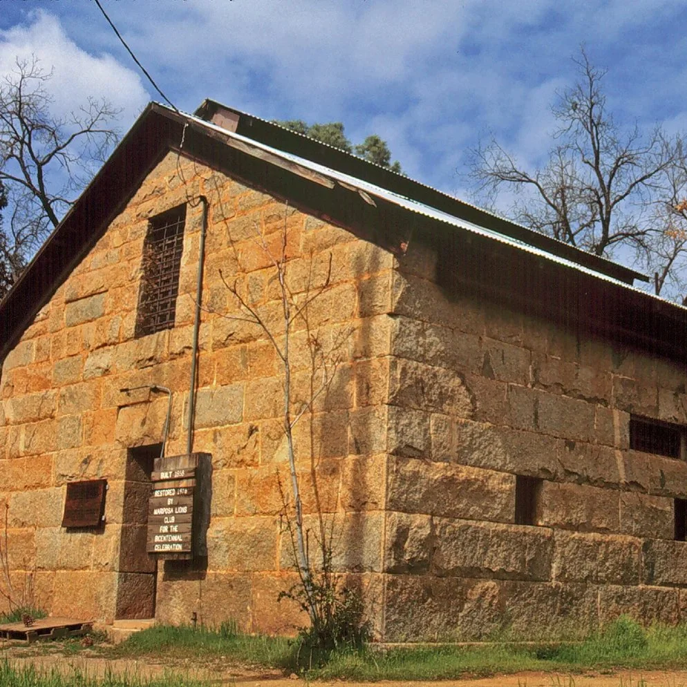 The Mariposa County Jail stands in granite silence on a small knoll above Bullion Street, looming over the town below. With its massive, twenty-four inch thick walls and tiny, iron-barred windows, it presents a bleak and foreboding appearance, remind