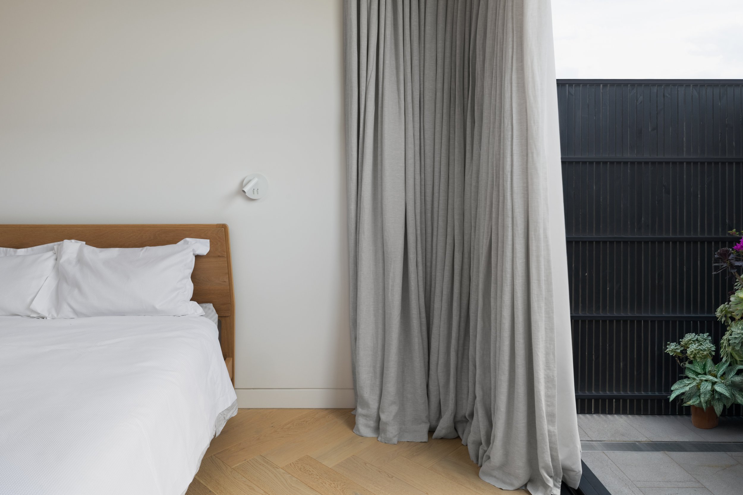 Main bedroom with sheer curtains softening natural light at Albert Park House.