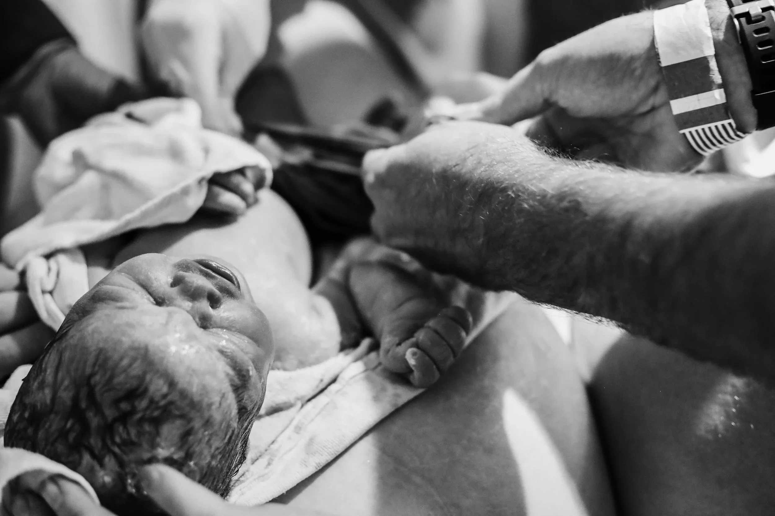 a dad cutting a newborn baby's umbilical cord