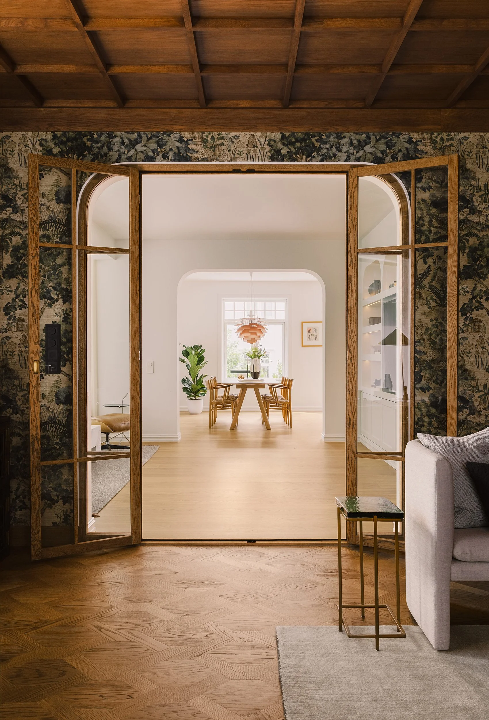 Eikedør med glassfelt mellom hjemmekontor og stue sett fra hjemmekontor.