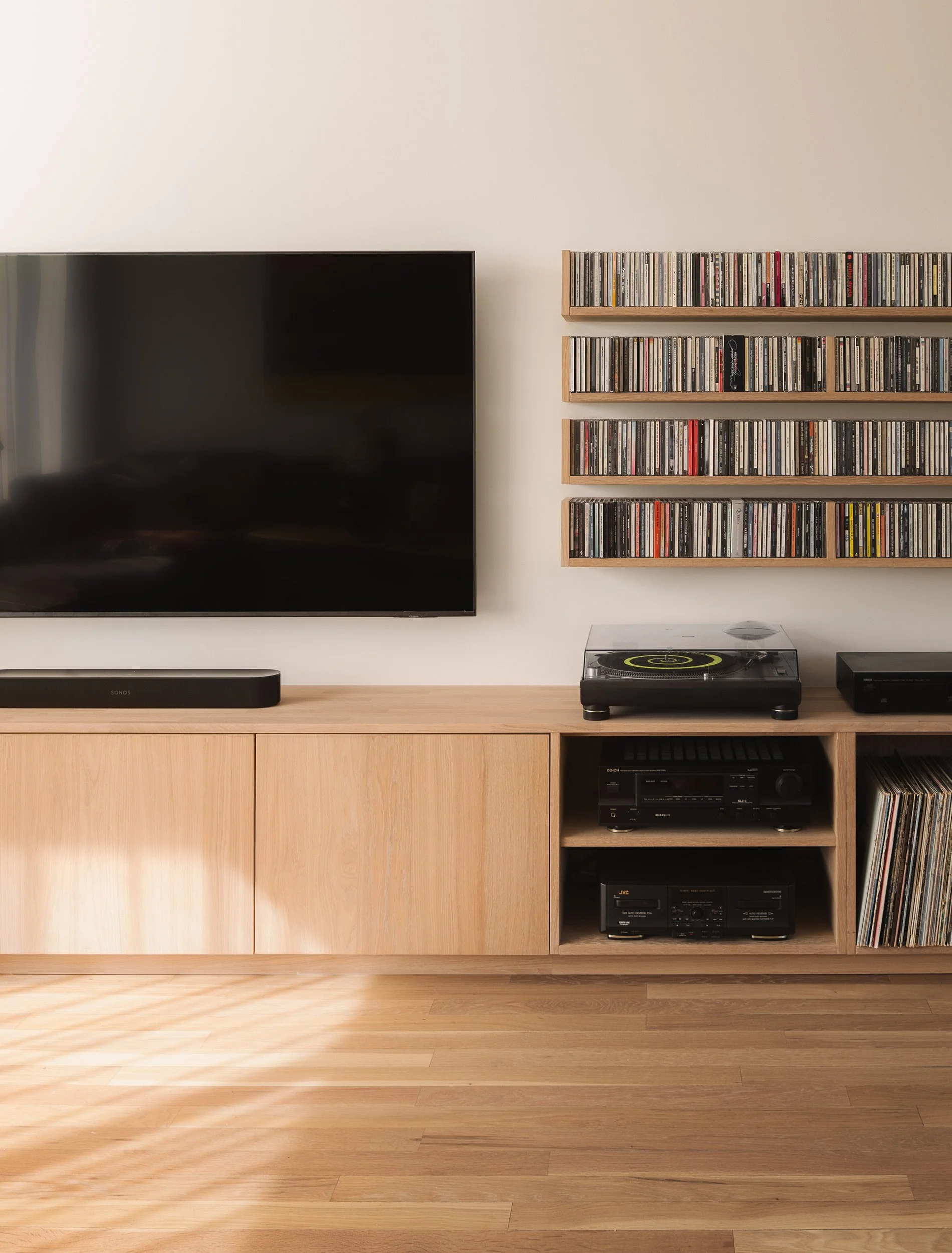 Spesialtilpasset mediainredning med TV, platespiller, vinyloppbevaring og vegghyller for CD-er.