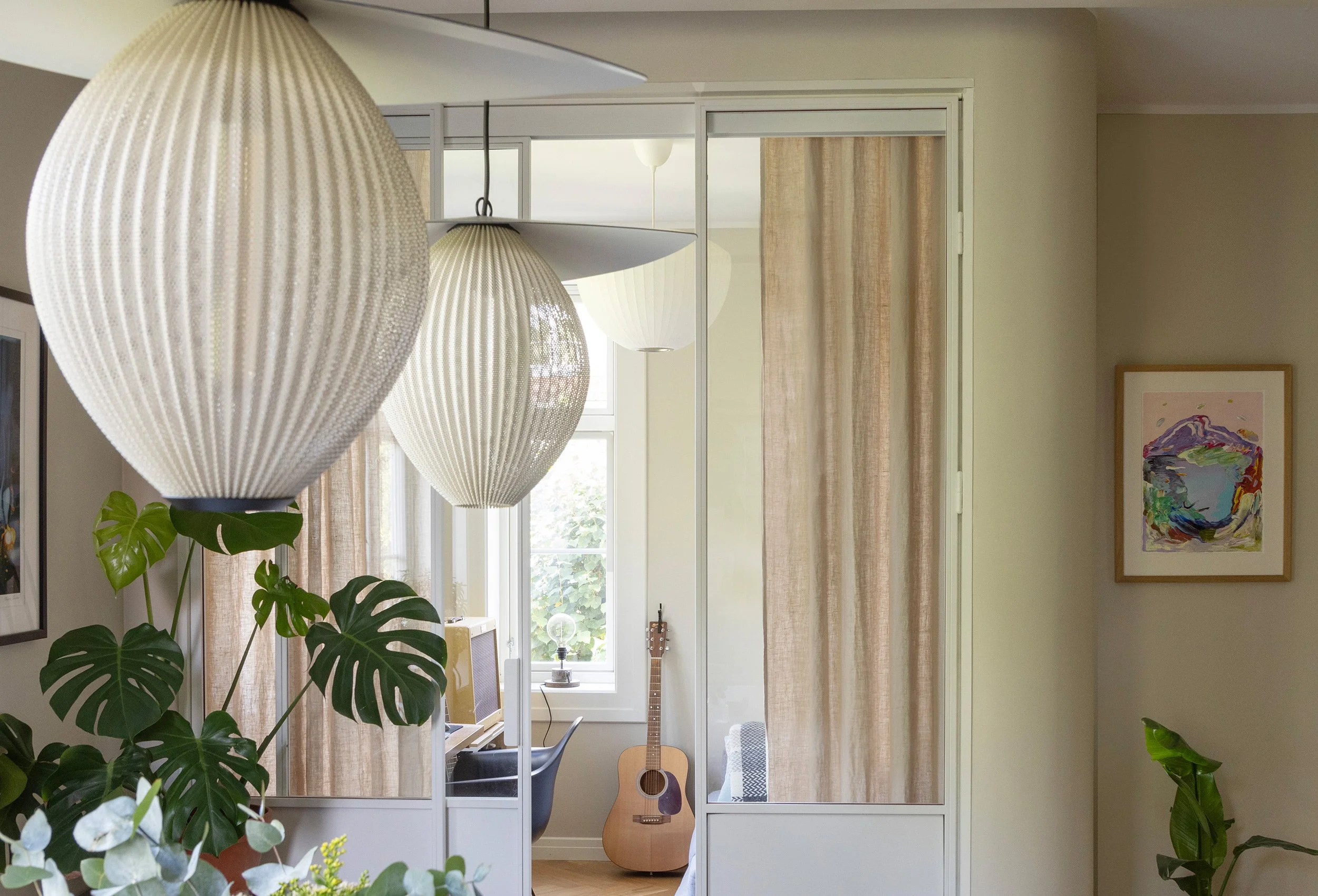 Glassfelt og skyvedør som fører dagslys og visuell kontakt mellom rommene.