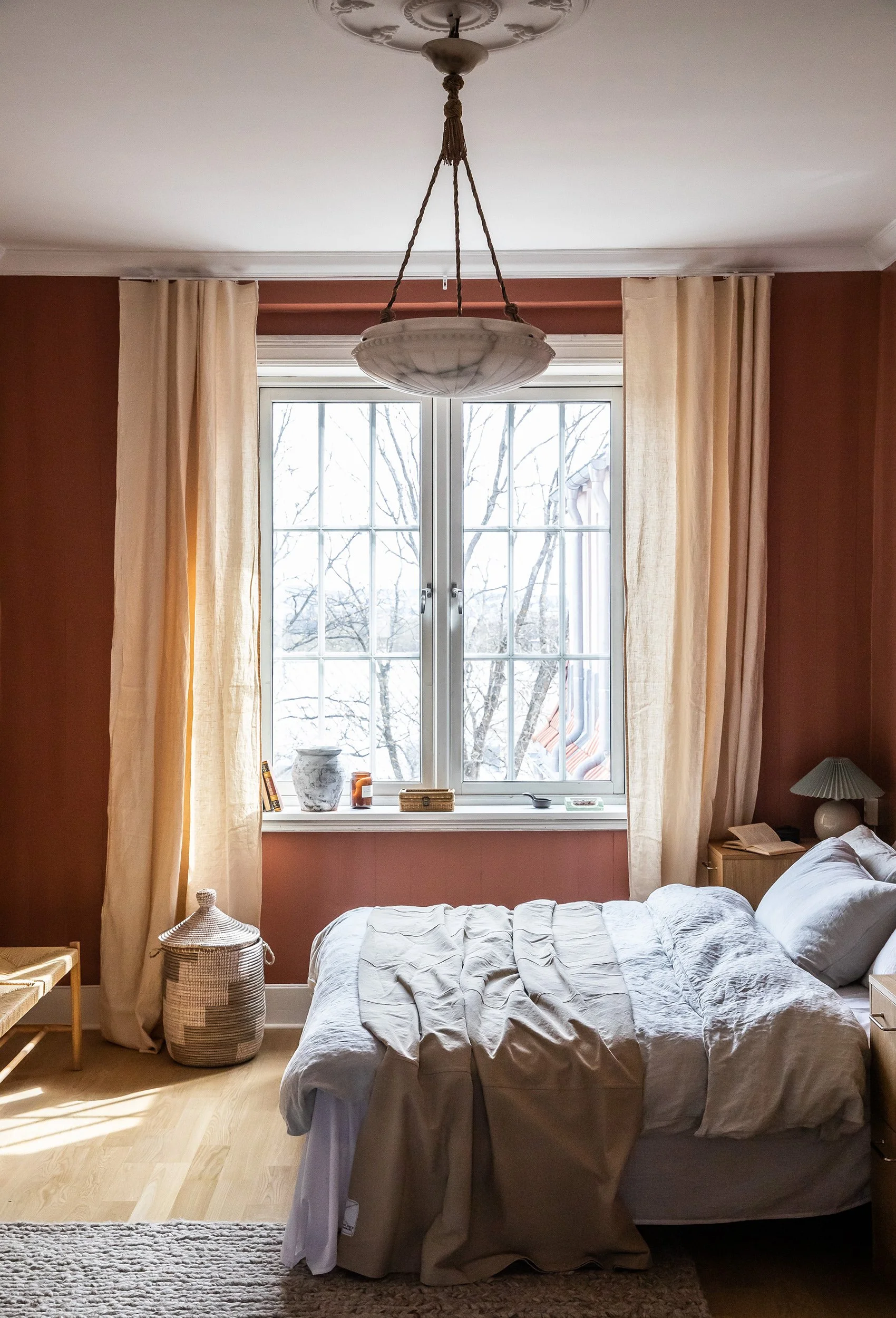 Hovedsoverom med varme terrakottatoner, eikegulv og morgensol fra bakgården.