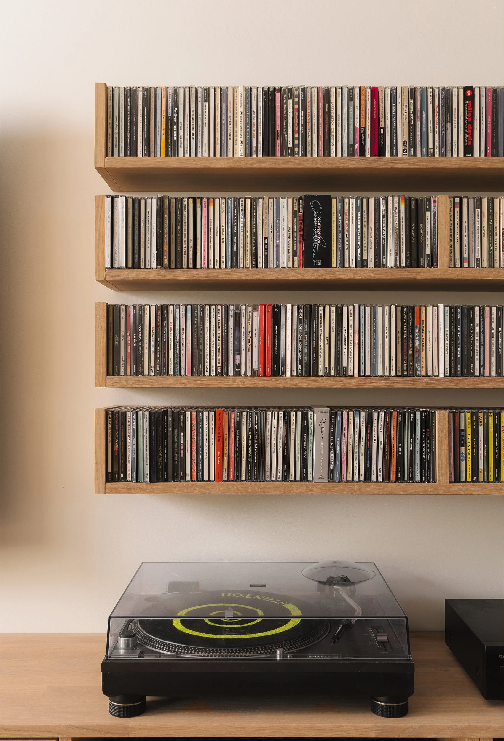 Platespiller og veggmonterte eikehyller til CD-samlingen.