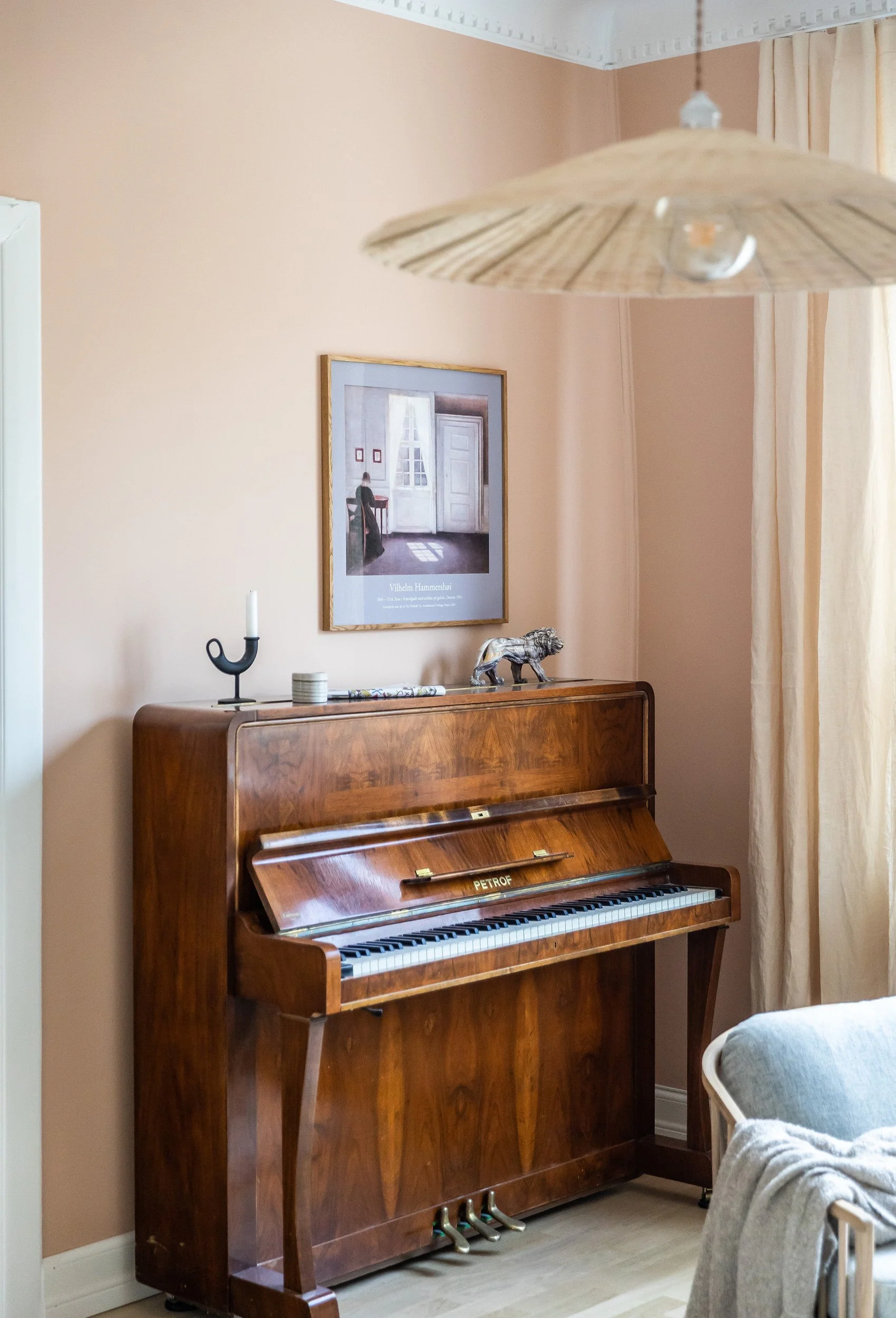 Piano mot varm terrakottafarget vegg i stuen.