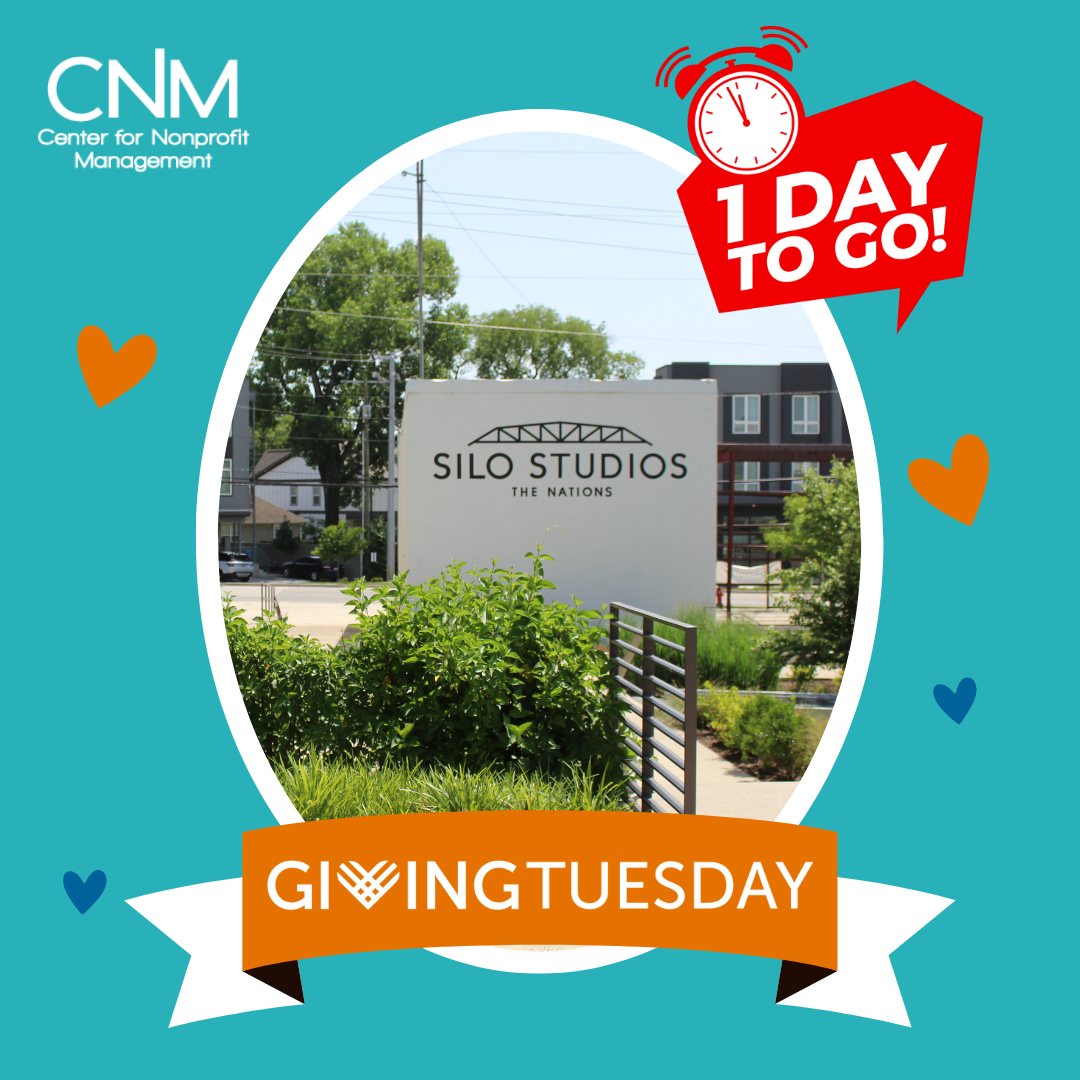 Sign that reads 'Silo Studios, The Nations' outside a building, with green plants and trees in the background. Overlay graphic with a red alarm clock and text '1 DAY TO GO!' and a banner with 'GIVING TUESDAY' on a blue background.