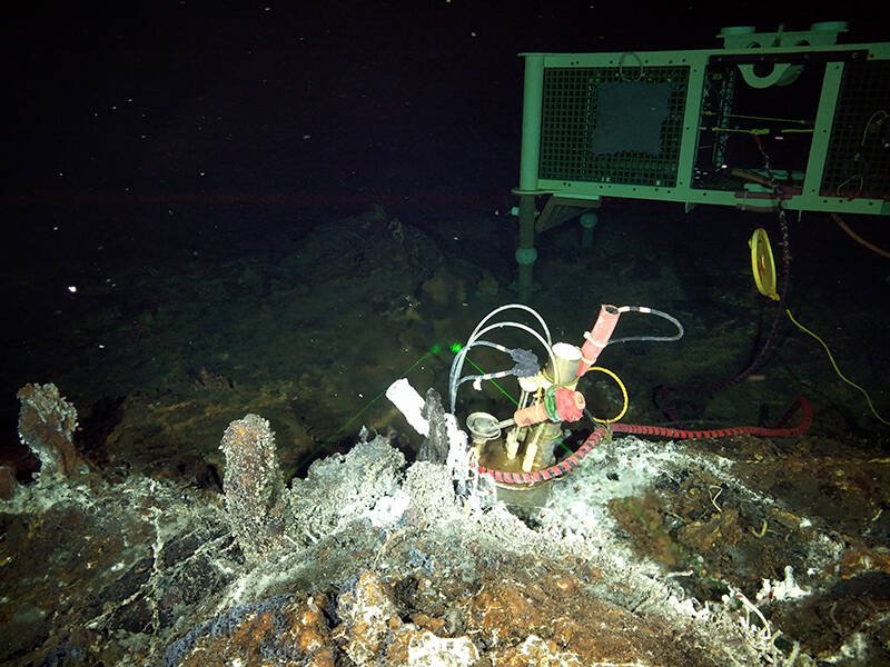 An observatory camera system on rocky surface on ocean floor.