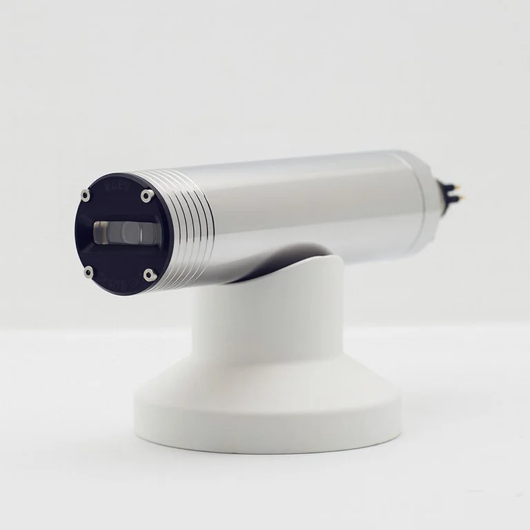 SubC Imaging SKATE MK2 underwater laser scanner shown on a white mount, featuring a cylindrical titanium body and front optical window.