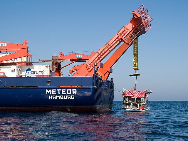 rov being lowered in to the ocean from a vessel