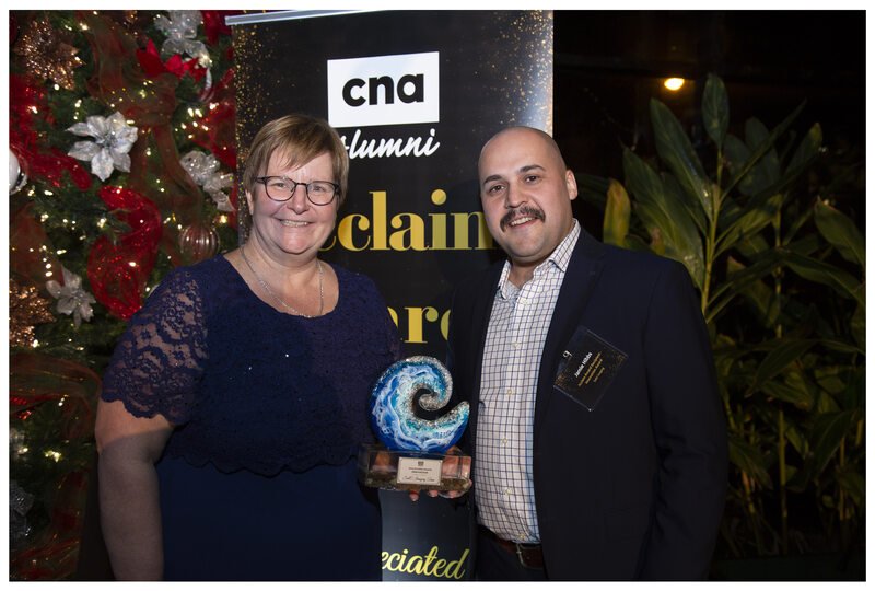 A woman in glasses presents an award to a man from SubC Imaging.