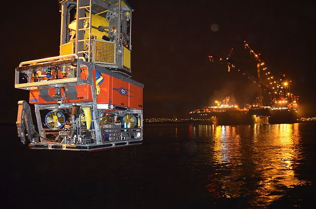 Orange ROV coming out of water at night