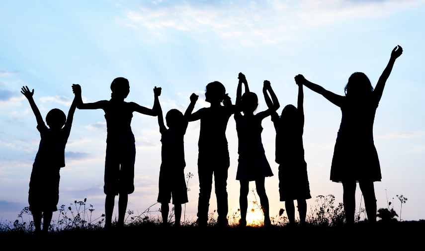 kids holding their hands in the sunset