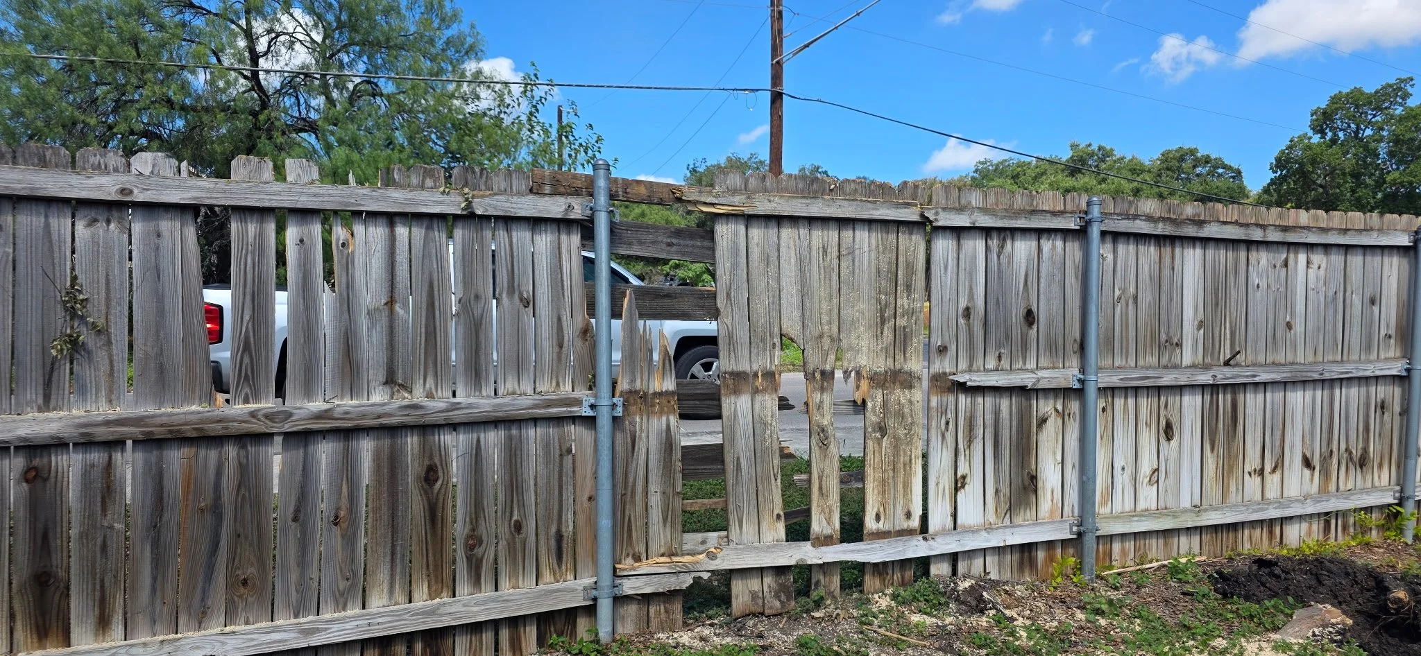 Before: Interior view showing deteriorated pickets and rails prior to the cedar fence repair.