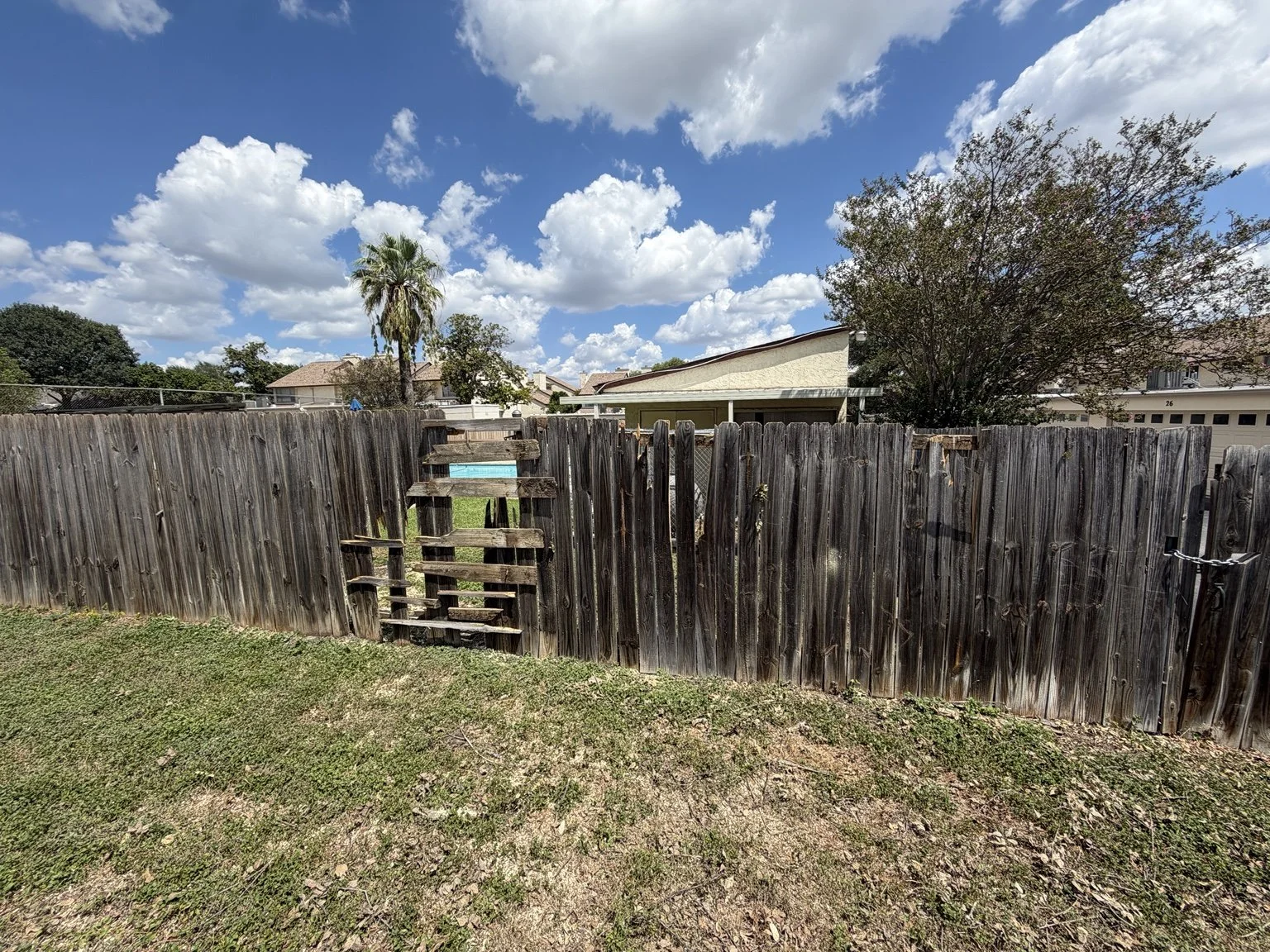 Before: Damaged and missing fence pickets at a San Antonio apartment complex.
