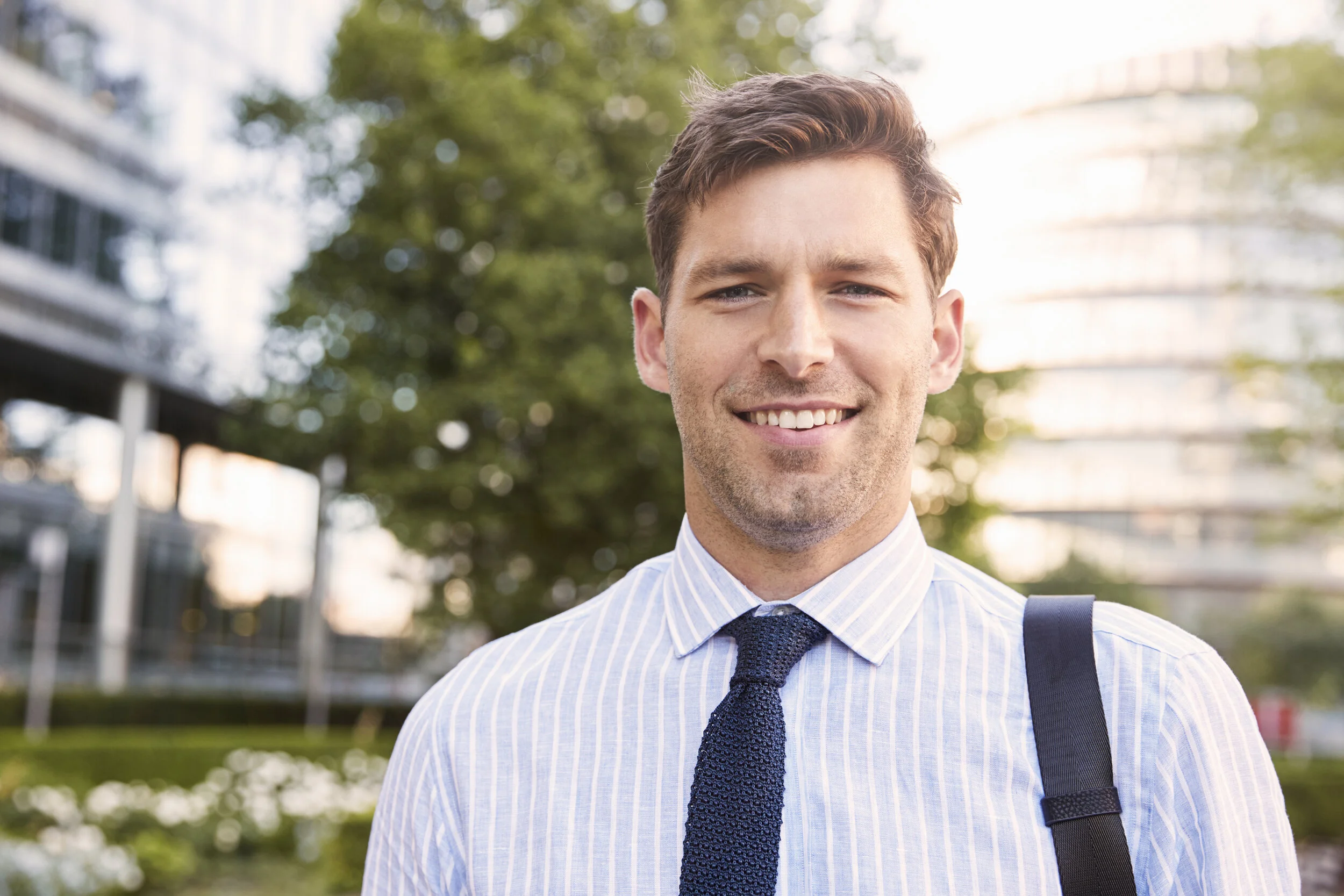 portrait-of-businessman-walking-through-city-on-wa-PXAKSUM.jpg