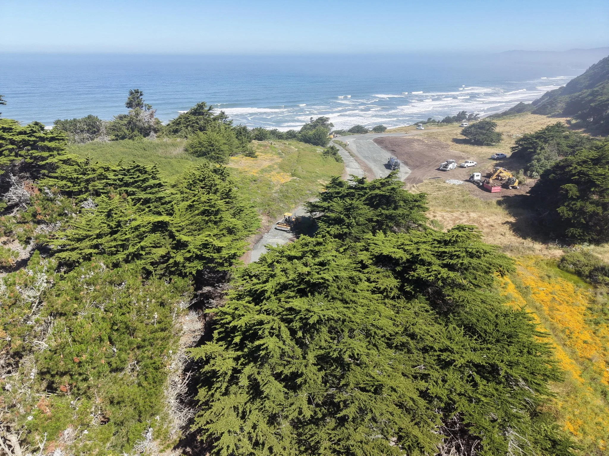 Aerial view of the project site overlooking the parking area and the ocean.