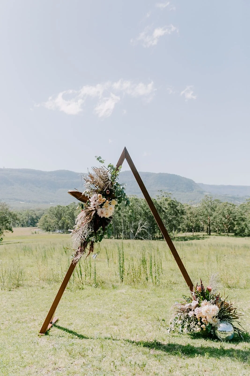 Triangular timber arbour available for hire in Sydney and NSW, ideal for rustic and boho wedding ceremonies and bridal entrances.