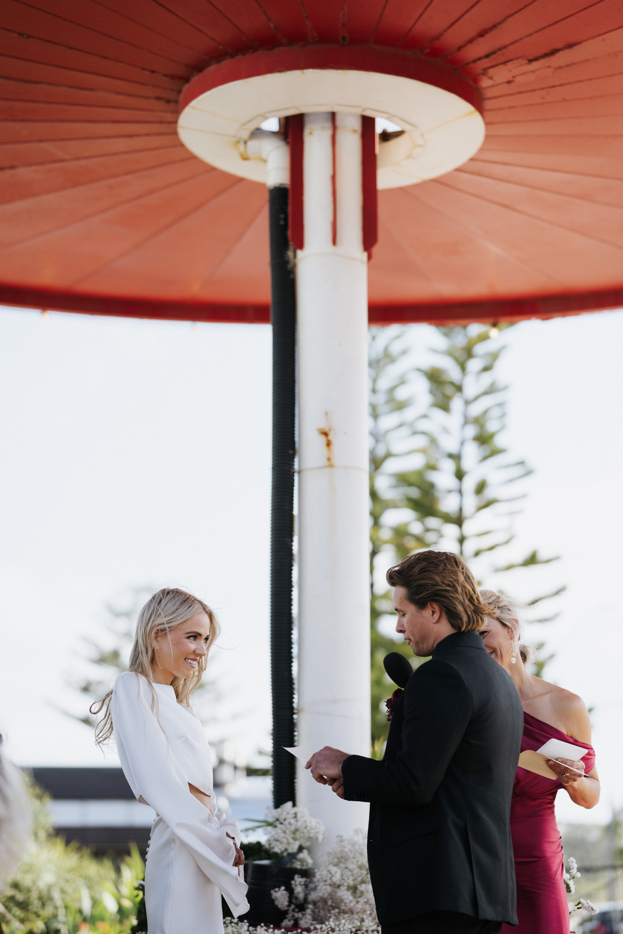 Jacqua Celebrant with Maggie and Dane exchanging rings at Port Kembla Servo. Photo credit: Damien Milan