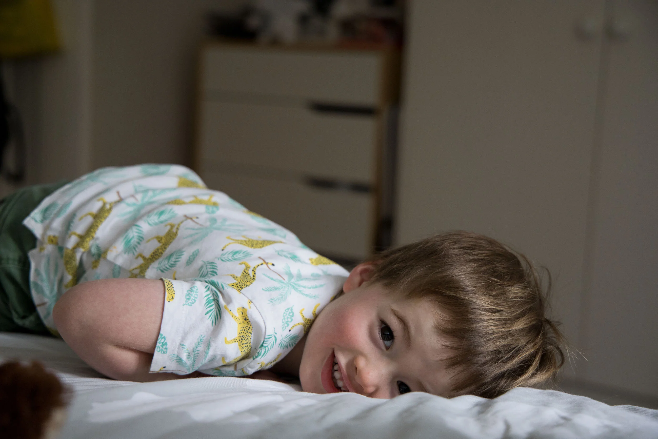 young boy lying on a bed