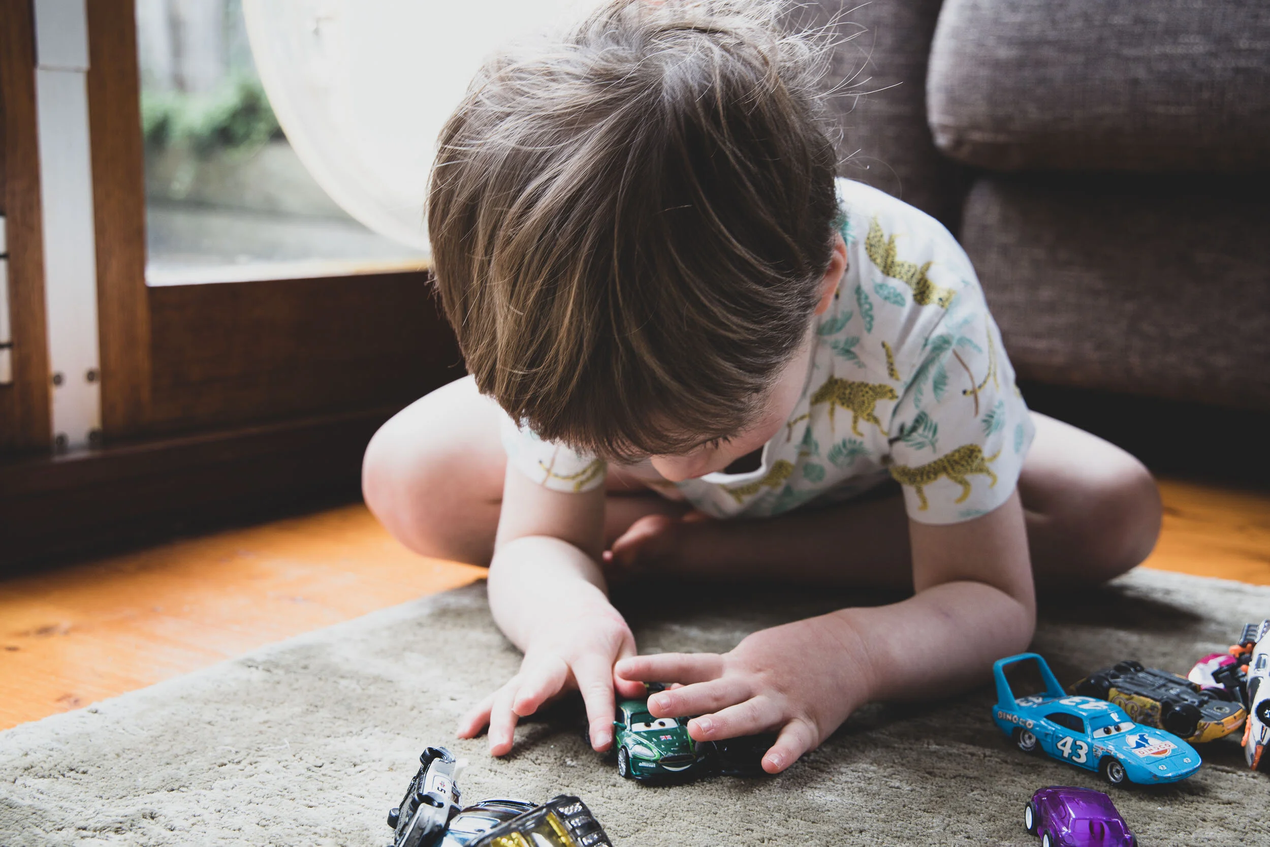young boy playing with toy cars