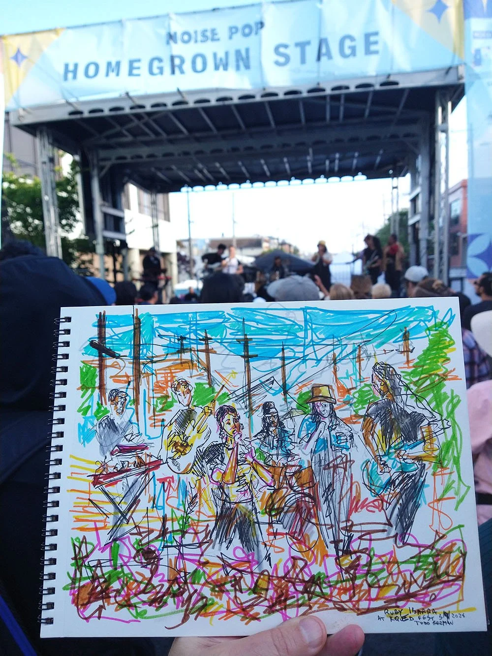 scribbly drawing of Ruby Ibarra held up in audience with outdoor stage in background