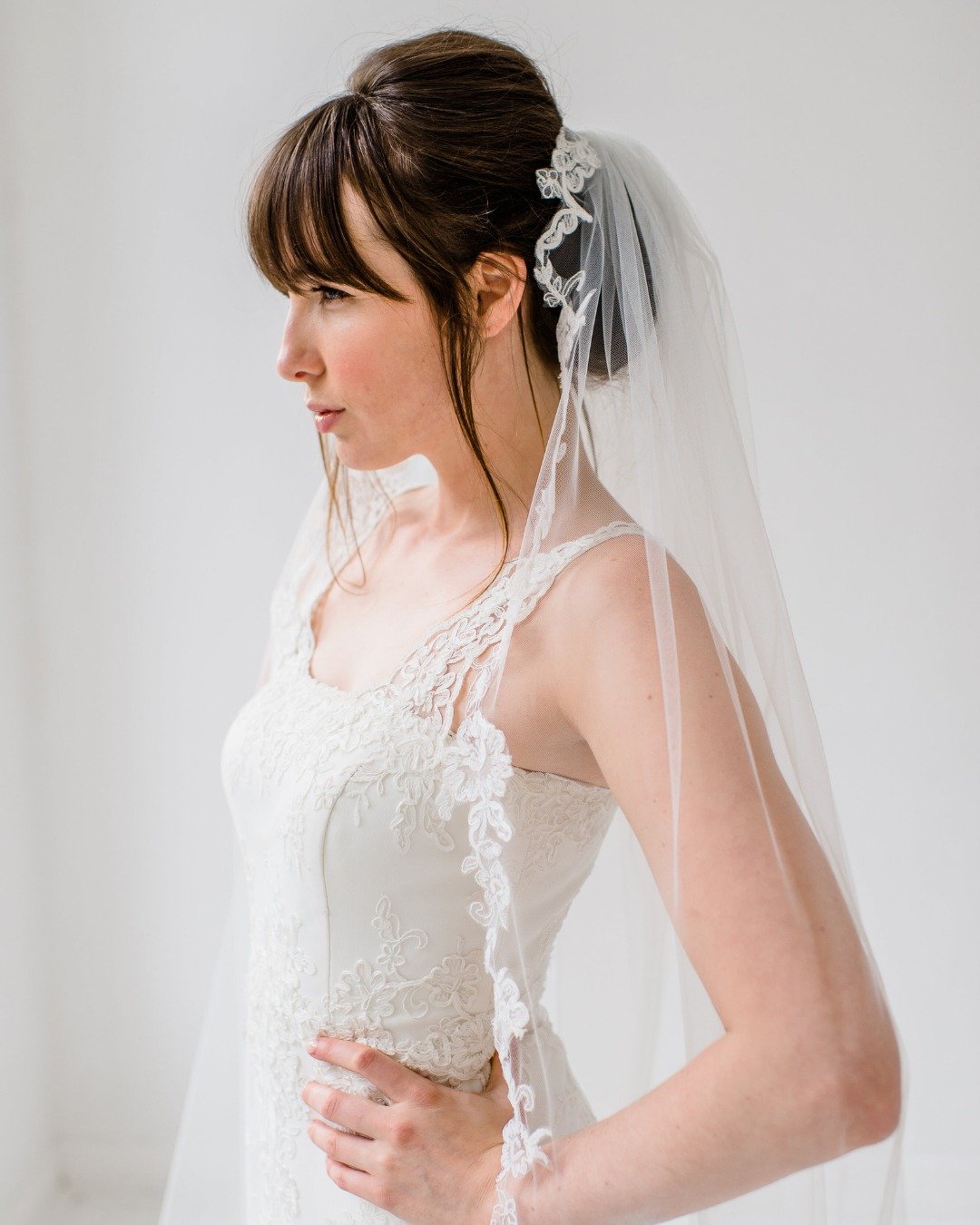 Soms zit de kracht van een japon in de verfijning. Deze prachtige kanten jurk met bijpassende sluier laat zien hoe details en belijning samen een tijdloze uitstraling vormen.

In ons atelier cre&euml;ren we samen met jou een outfit die past bij jouw 